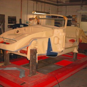 Beispiel: Restauration eines 356/T6 Cabrio-Karosserie. Ohne Außenverkleidung auf der Rahmenlehre. Grundaufbau/Restaurationsabschnitt - fixieren der Achsaufnahmepunkte, Einbau der tragenden Teile wie Bodenbleche, Längsträger, Diagonalverstrebung, Batteriekasten etc. Alle Karosserieteile werden nach original Karosserieplänen und Werkmaßen eingebaut und verschweißt, nur so kann eine optimale Maßhaltigkeit und Statik der Karosserie gewährleistet werden.