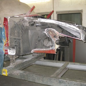 Nach den Richtarbeiten, Fahrzeug auf der Richtbühne. Aussenverkleidung, Batteriekasten und Vorderachskörper herausgetrennt, Anschlussbleche und Oberwagen gerichtet.